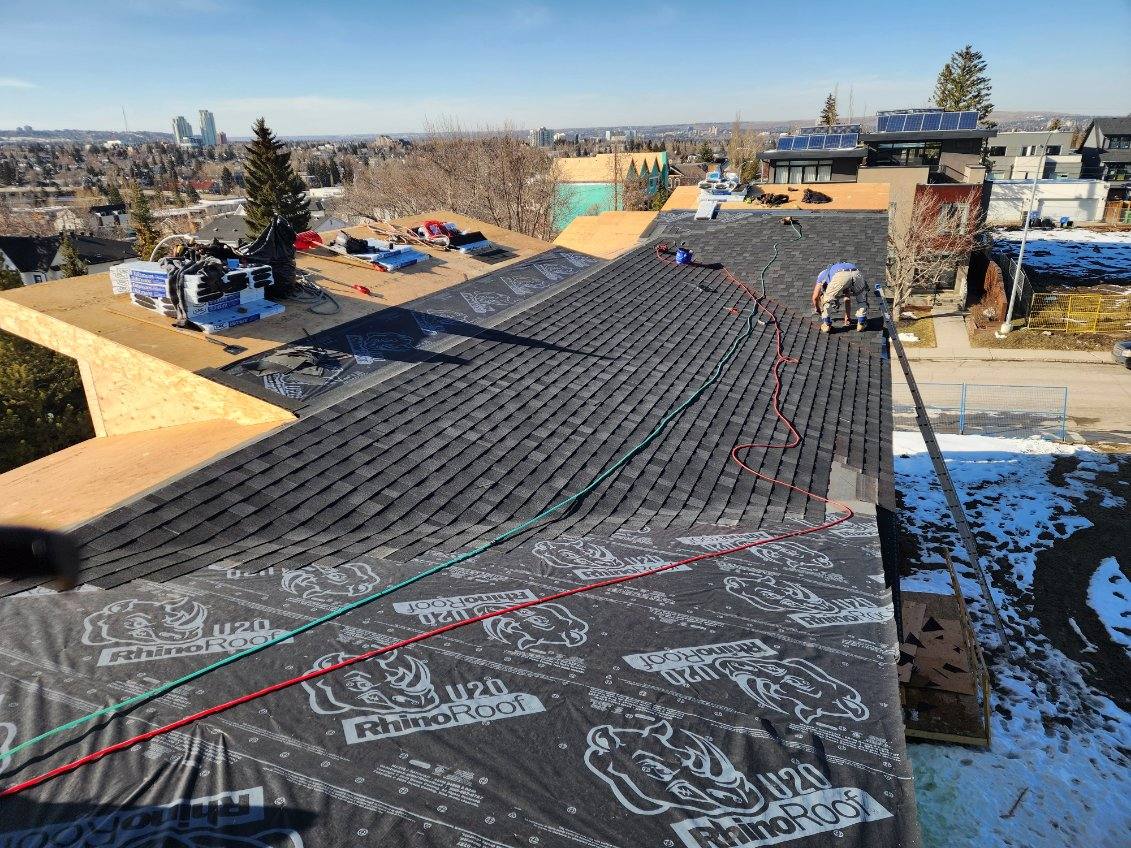 Crew installing underlayment ahead of new shingles
